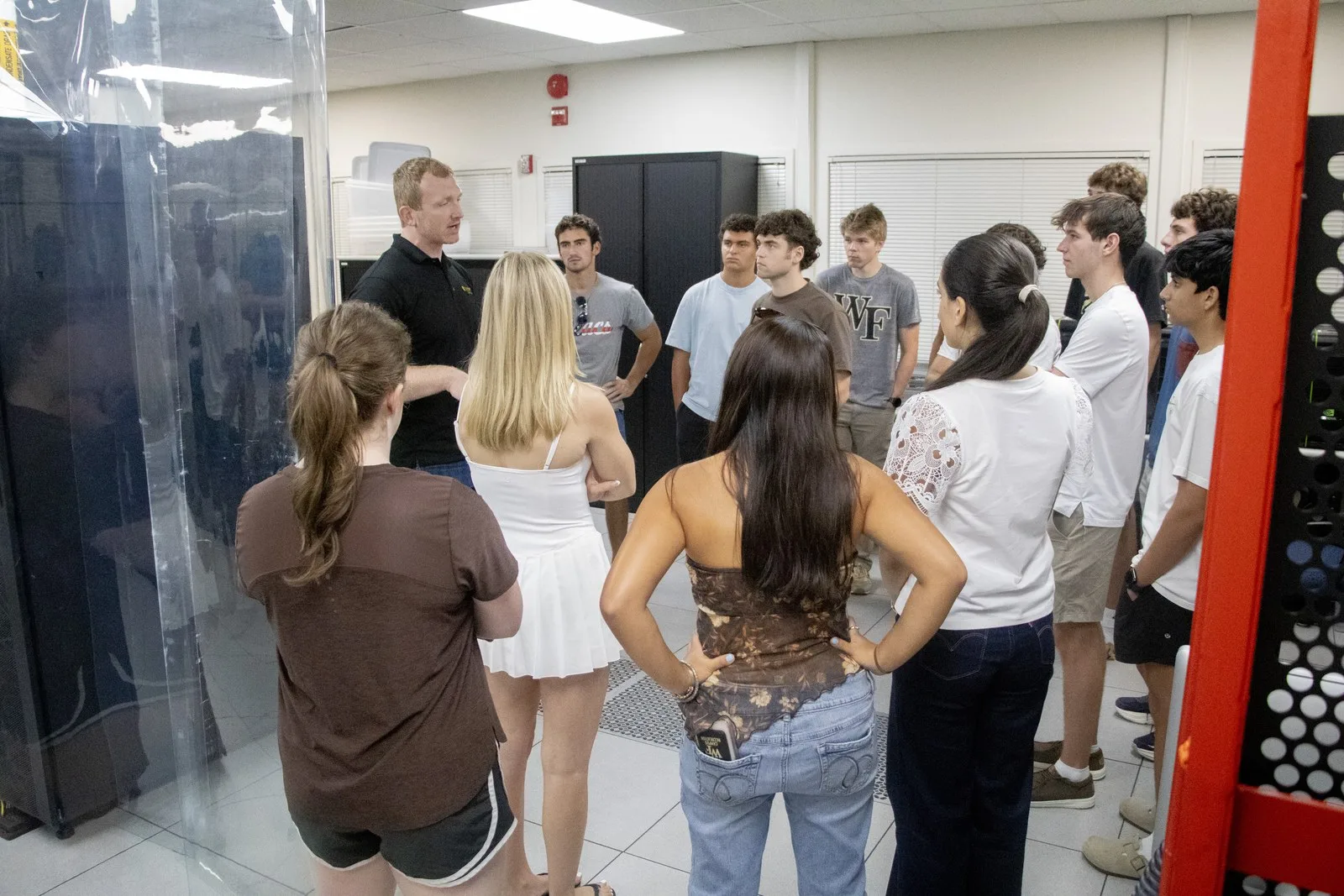 Students gather in a data-center aisle around an HPC staff member.